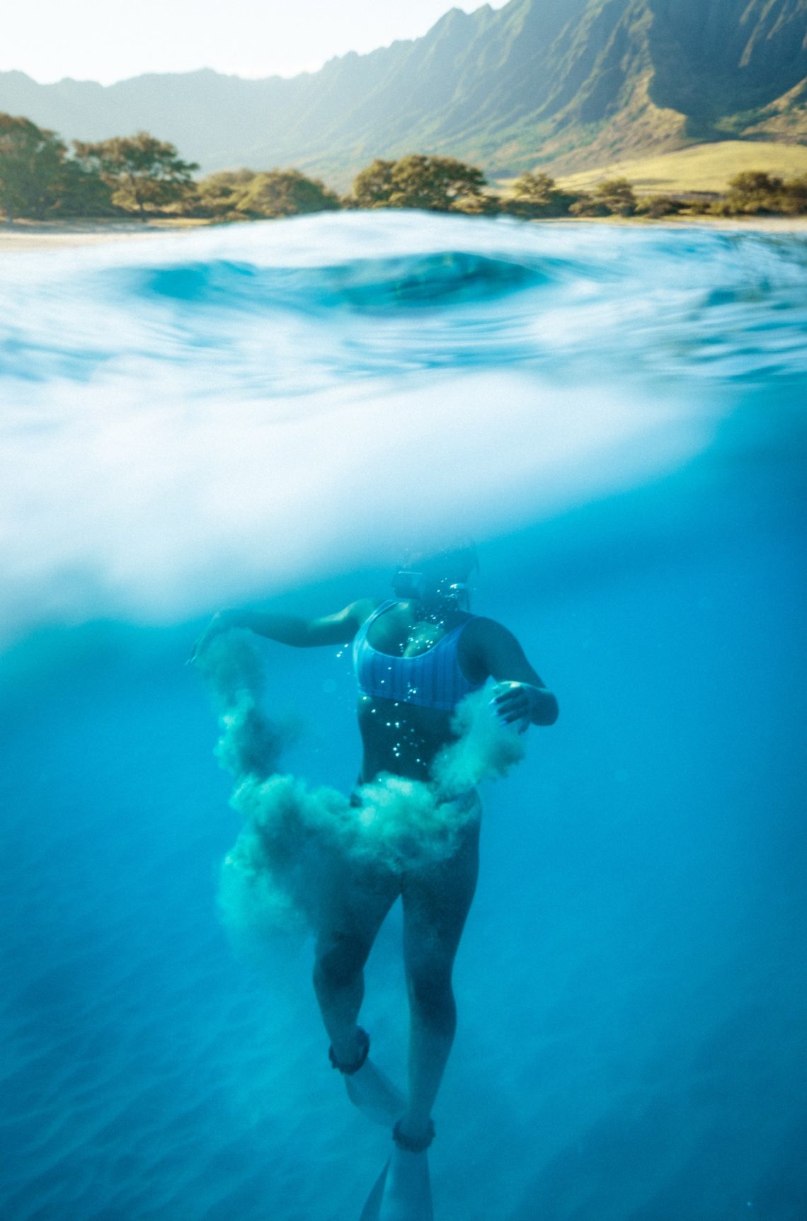 A person diving in the blue water of Hawaii
