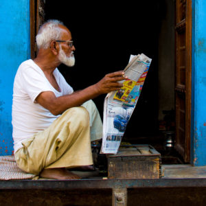 An elderly man reading a newspaper