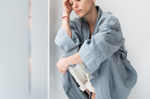 A woman with a shaven head looking worried.