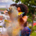 A woman throwing a cloud of multi-coloured particles