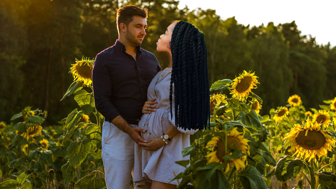 A white man with a black woman in a field of sunflowers