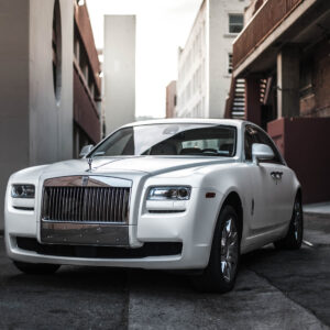 A White Rolls Royce Parked In A Street