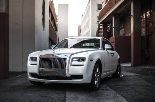 A White Rolls Royce Parked In A Street