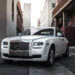 A White Rolls Royce Parked In A Street