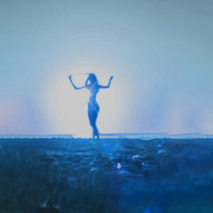 A blue toned image of a woman dancing in the sunlight