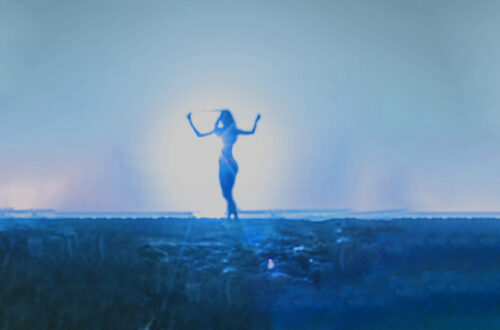 A blue toned image of a woman dancing in the sunlight