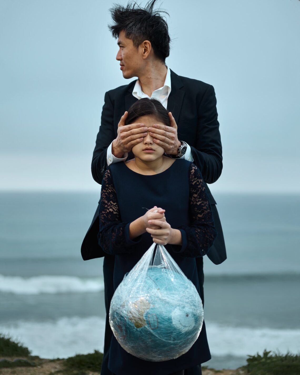 Man and Girl with globe in plastic bag.