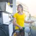 A young woman filling her car's gas tank