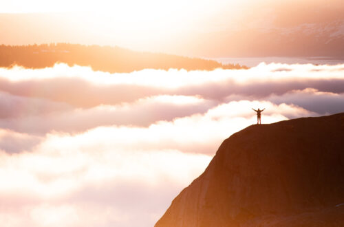 A man on a high mountain looking at the view.