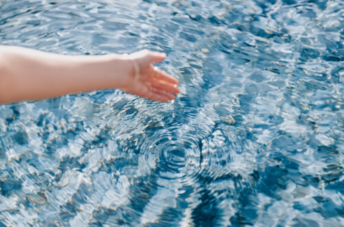 A hand above a mysterious pool of blue water