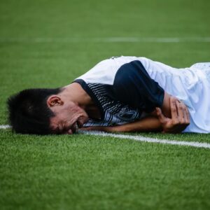 A socker player in pain, or acting as if he is in pain.