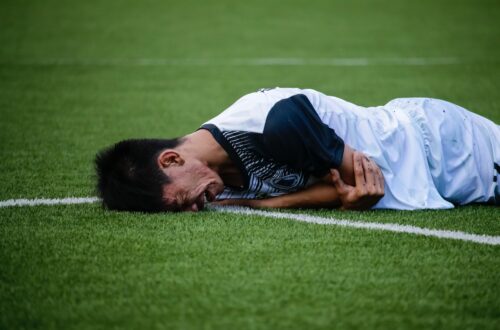 A socker player in pain, or acting as if he is in pain.