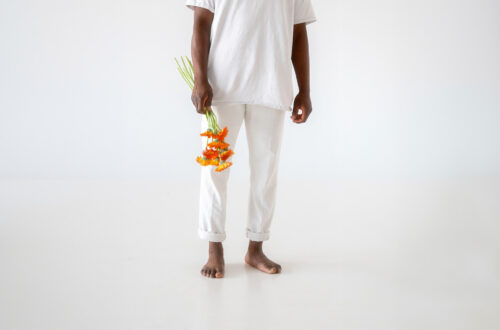 A person dressed in white holding a bunch of flowers