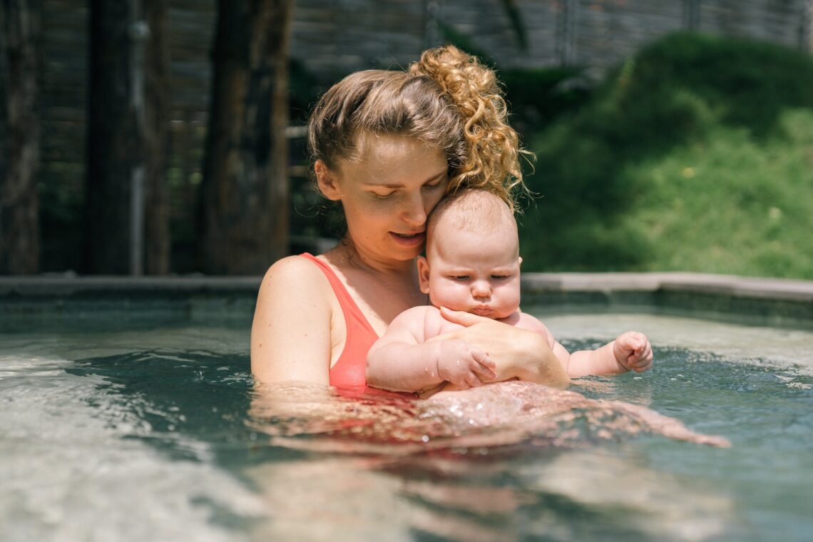 A mother with her child in a watery pool