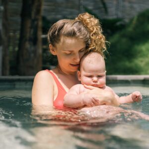 A mother with her child in a watery pool